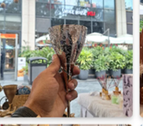 Handmade wind chimes from India held in an artisan's hand at a trade display