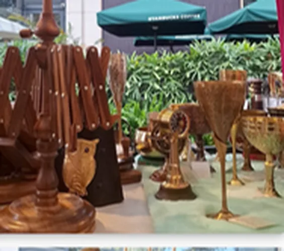 Handmade metal bells and décor arranged at an outdoor exhibition stand